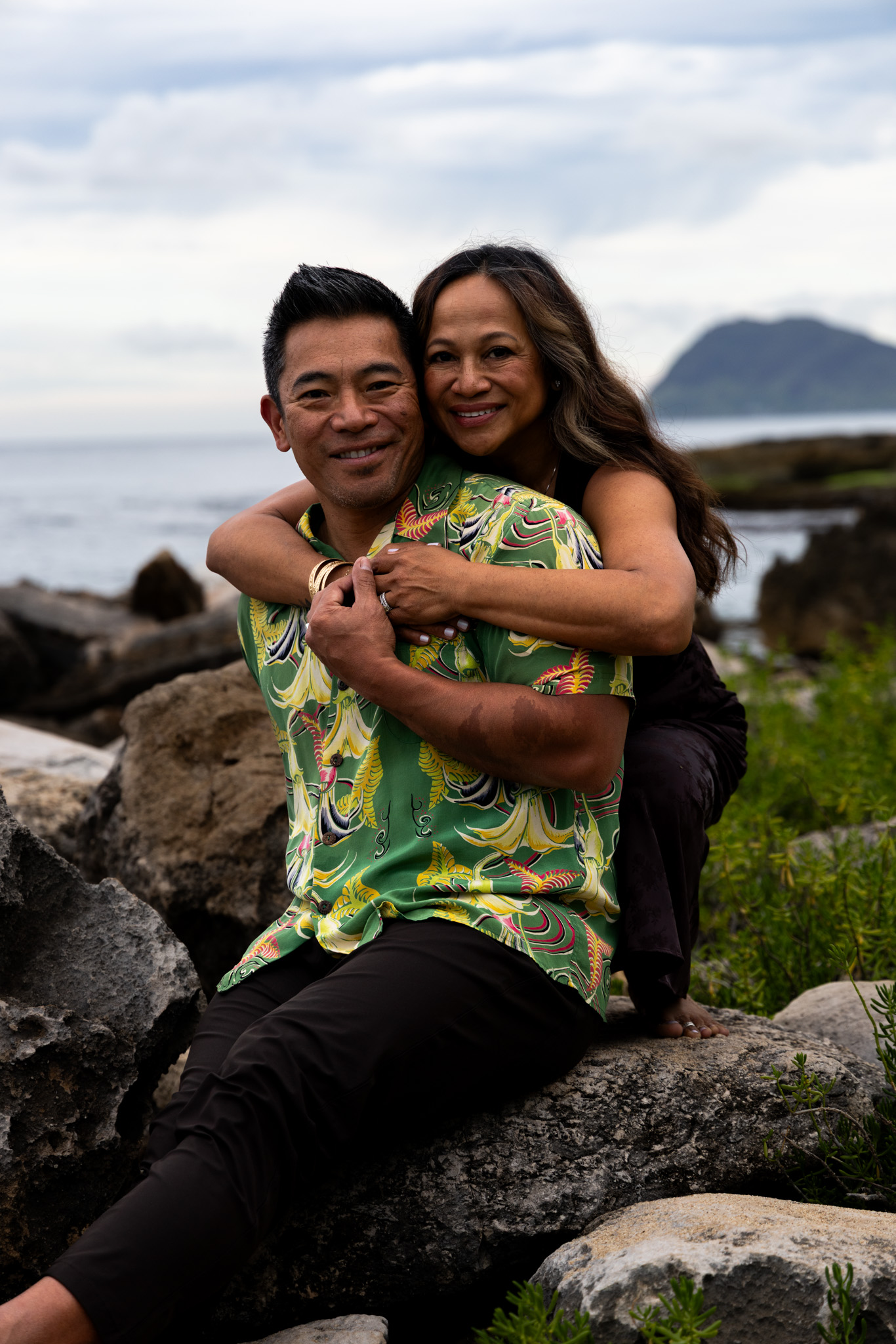 Couple embracing on the rocky Ko Olina coast, Oahu