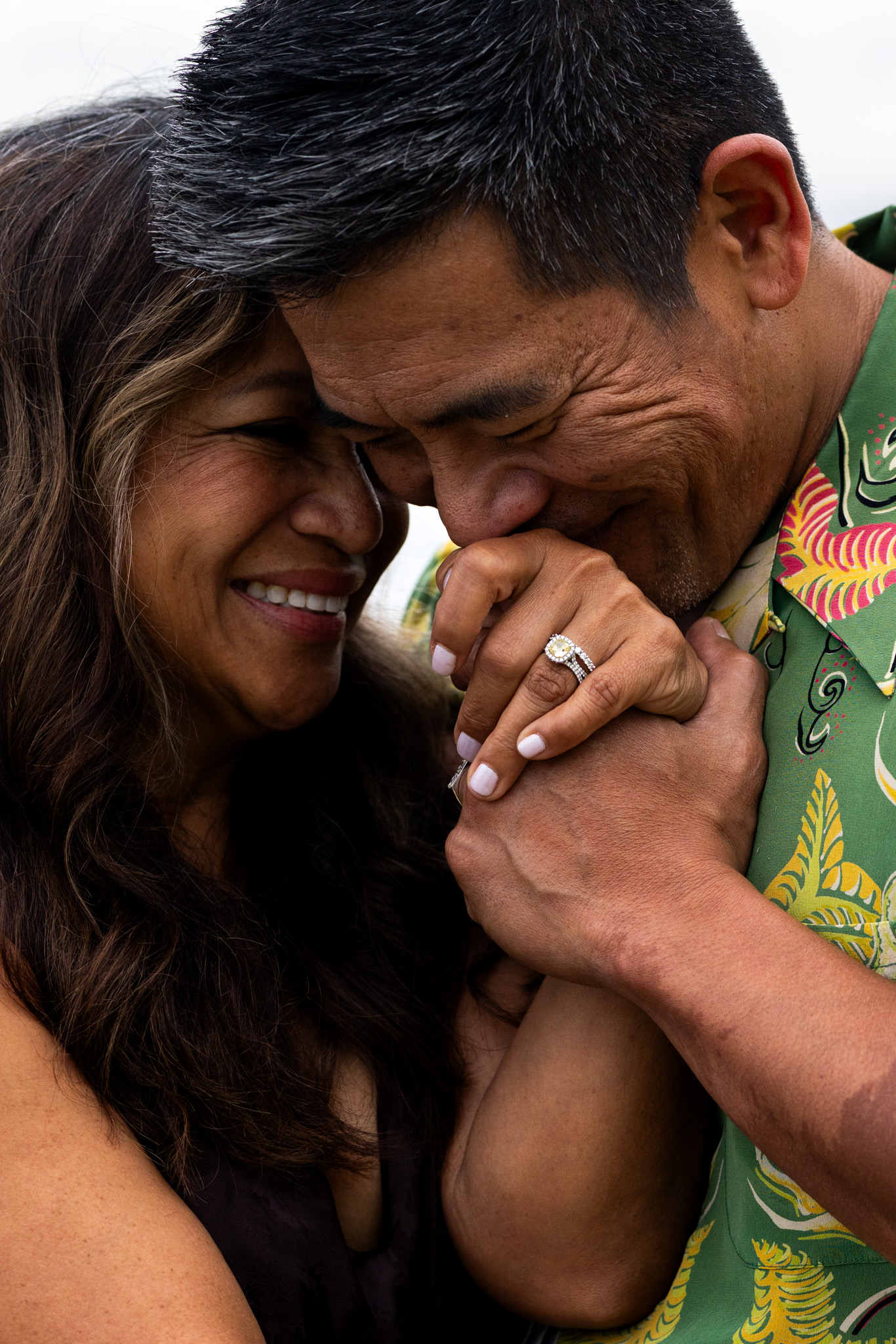 Groom kisses bride's hand showing her ring, Ko Olina Oahu